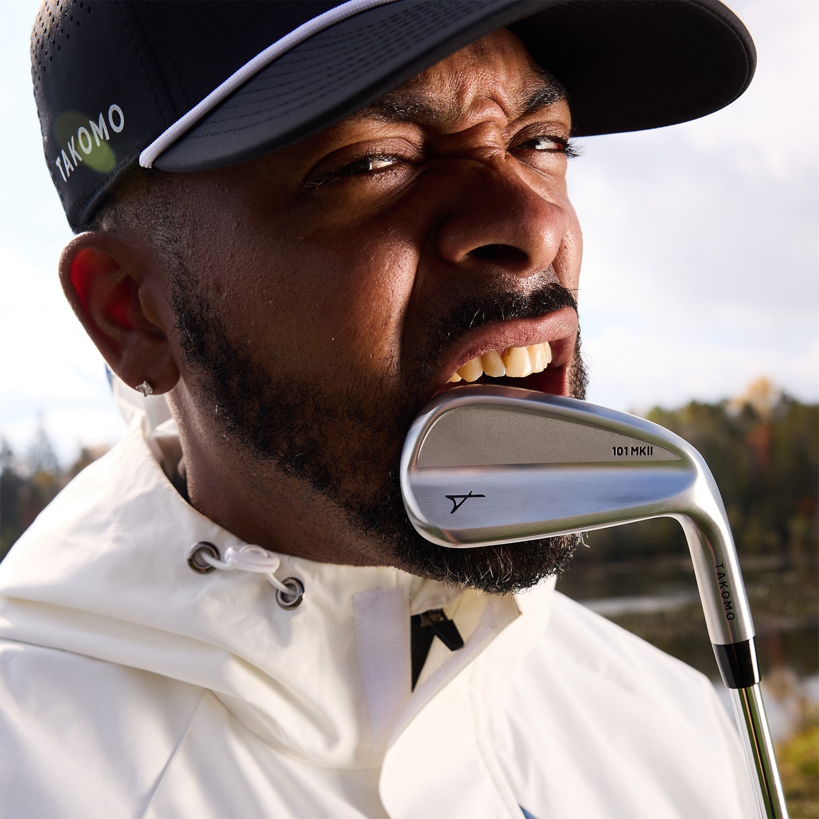 Takomo campaign photograph, a golfer biting a 101 MKII iron